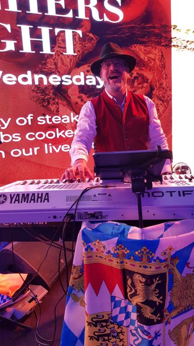 Mick am Keyboard mit großer Video-Leinwand im Hintergrund in Bahrein auf dem Oktoberfest